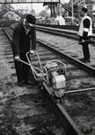169027 Afbeelding van een wegwerker van de N.S. tijdens werkzaamheden aan de spoorlijn bij Utrecht Maliebaan, met ...